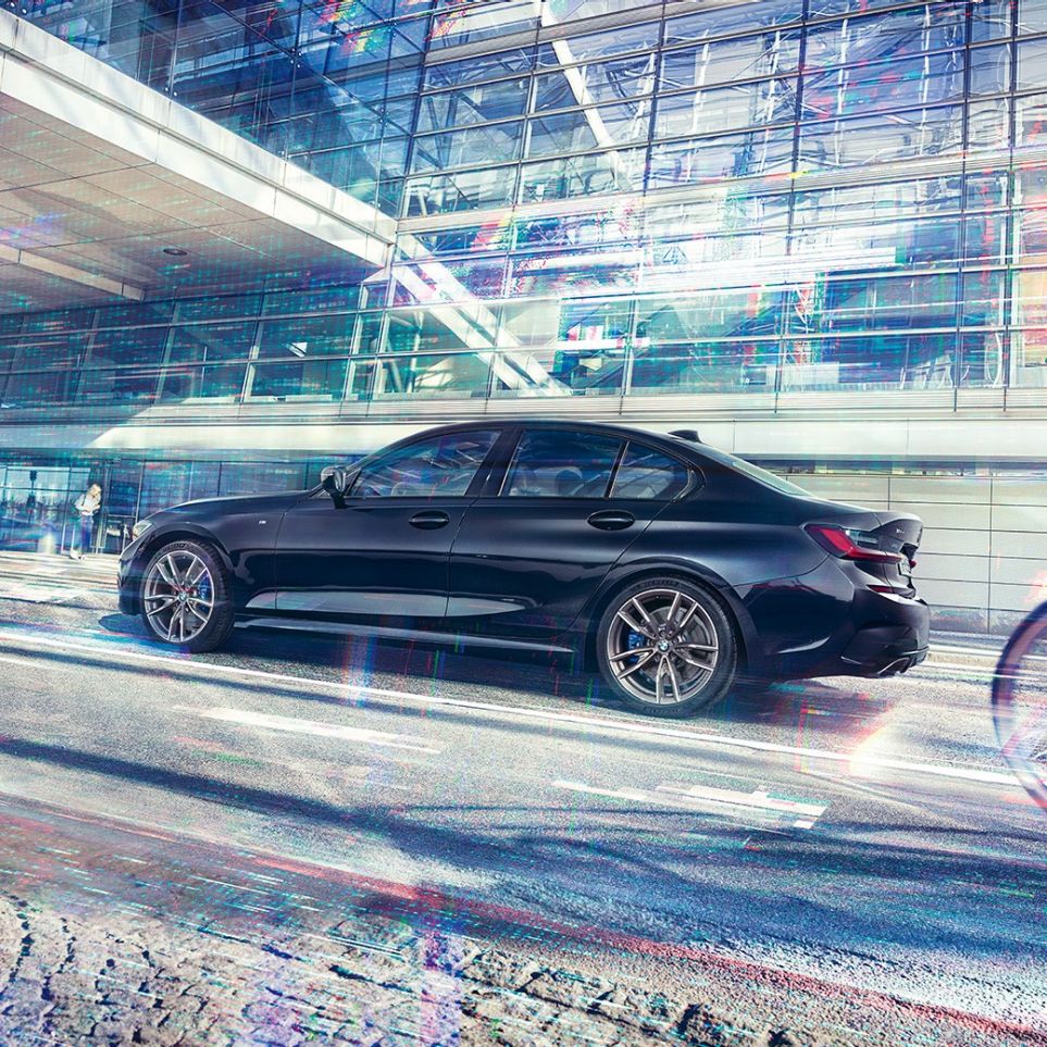 BMW Série 3 Berline, modèle M340i xDrive. Vue latérale de la BMW M340i xDrive à l'arrêt devant un bâtiment urbain.