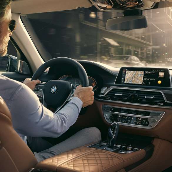 Fonctionnalités Connectivity de la BMW Série 7 BMW Série 7 Berline : homme assis à bord de la BMW en train d’utiliser les fonctionnalités Connectivity