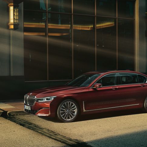 BMW Série 7 Berline Individual, vue latérale Vue latérale d’une BMW Série 7 Berline Individual rouge dans un décor urbain