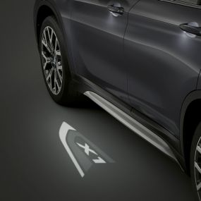 BMW X1, projection LED « X1 ». BMW X1, vue de profil avec vue sur la projection LED « X1 ».