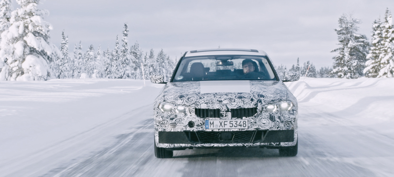 La BMW Série 3 en action Prototype secret de la BMW Série 3 dans la neige dans un paysage sauvage.