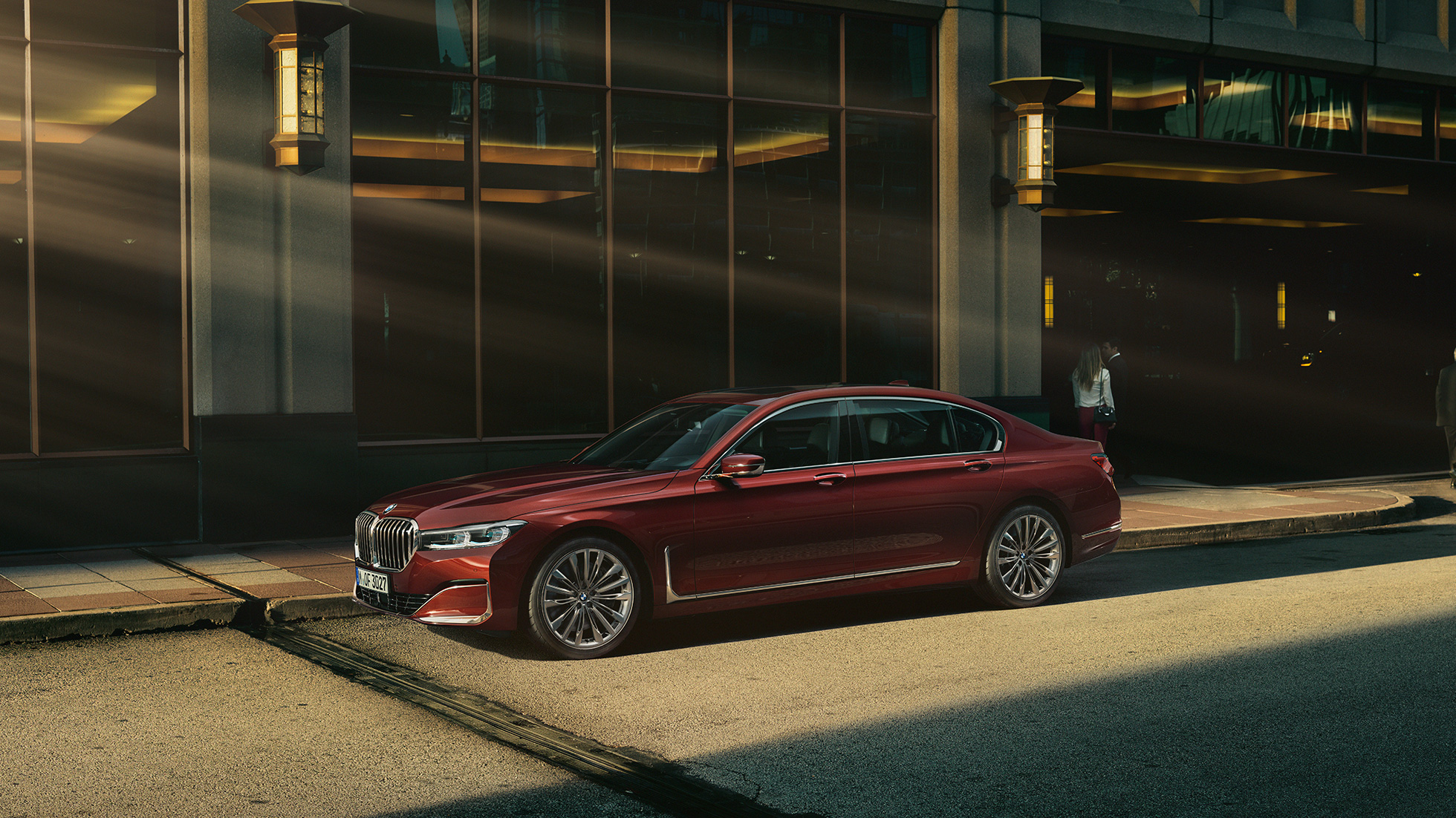 BMW Série 7 Berline Individual, vue latérale Vue latérale d’une BMW Série 7 Berline Individual rouge dans un décor urbain