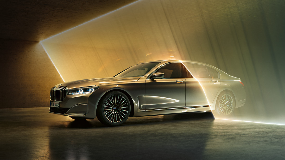 La BMW Série 7 Berline vue de trois quarts avant BMW Série 7 Berline : vue de trois quarts avant d’une BMW grise entourée de rayons lumineux
