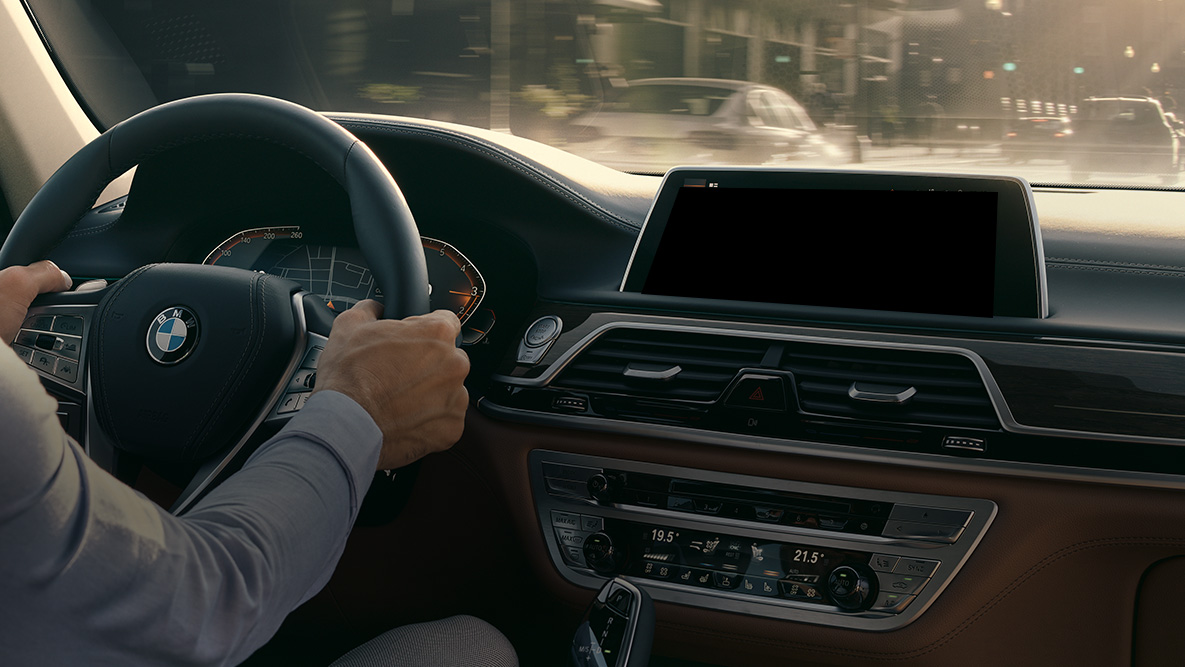 BMW Intelligent Personal Assistant BMW Intelligent Personal Assistant : homme en train de conduire une BMW, vue en gros plan du Live Cockpit Professional