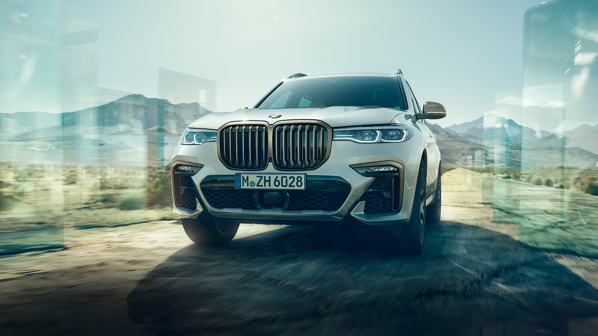 BMW X7 M50d, vue en contre-plongée diagonale BMW X7 M50d : vue en contre-plongée diagonale d’une BMW X7 de couleur blanche en mouvement