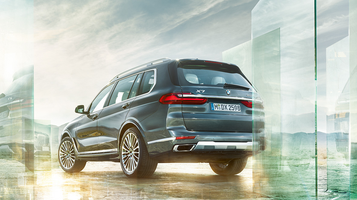 Le confort et la dynamique de conduite de la BMW X7 Vue de trois-quarts arrière de la BMW X7 devant un décor abstrait