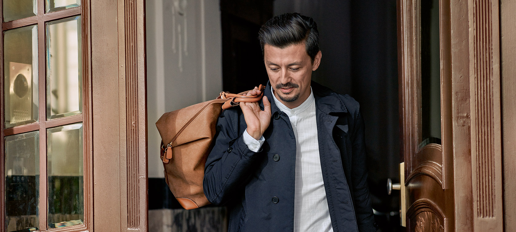 Service haut de gamme BMW Service BMW : Un homme portant un sac sur son épaule se tient devant une porte